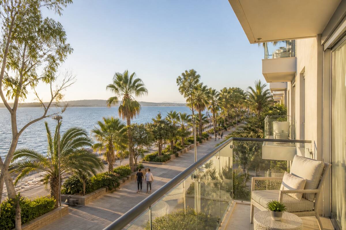 Vakantie vergelijken: een rustige kustlocatie met hotel en wandelende mensen