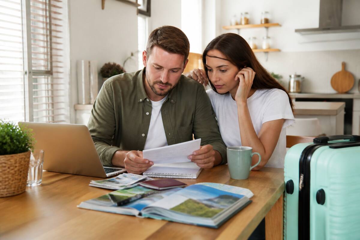Een checklist en reisgidsen bij een laptop voor stressvrij vakantie plannen